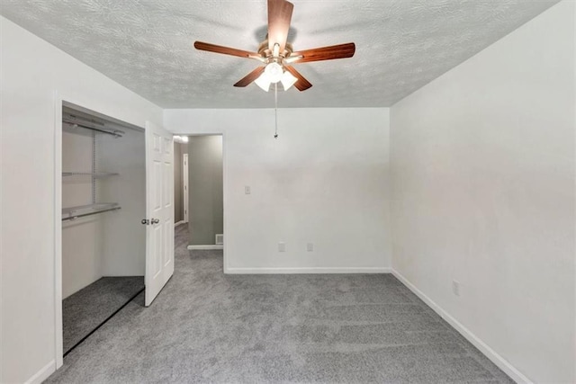 unfurnished bedroom with a textured ceiling, a closet, carpet, a ceiling fan, and baseboards