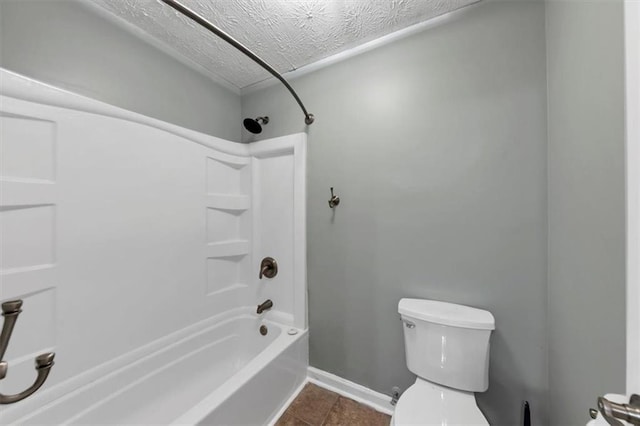 bathroom featuring toilet, a textured ceiling, tile patterned floors, shower / washtub combination, and baseboards
