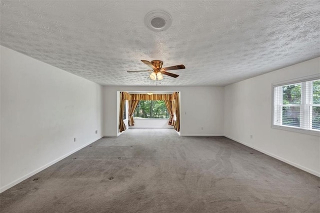 spare room featuring a ceiling fan, carpet flooring, baseboards, and a textured ceiling