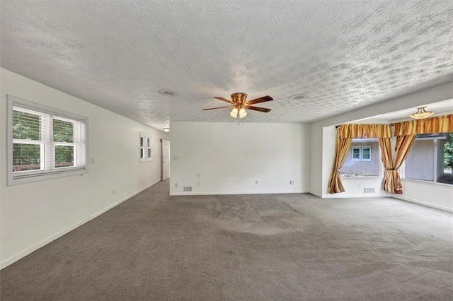 unfurnished living room with carpet floors, a textured ceiling, a ceiling fan, and baseboards