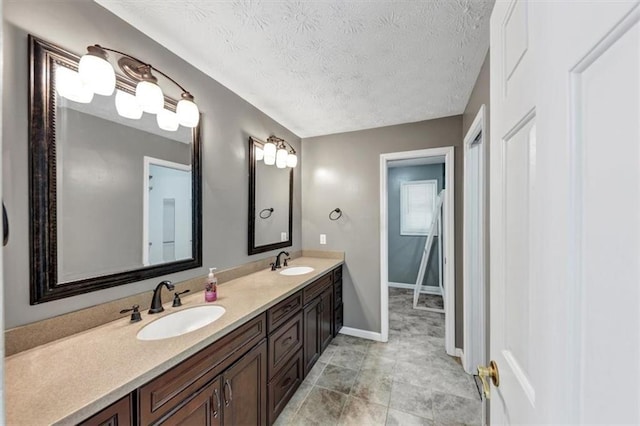 full bathroom featuring double vanity, baseboards, and a textured ceiling