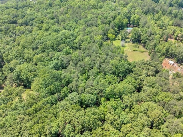 view of property location with a heavily wooded area