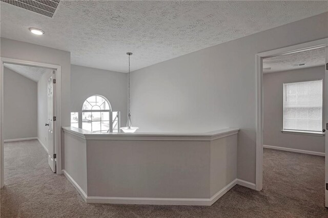 hallway featuring carpet floors and a textured ceiling