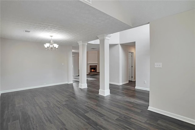 unfurnished living room with a chandelier, a textured ceiling, and dark wood-type flooring