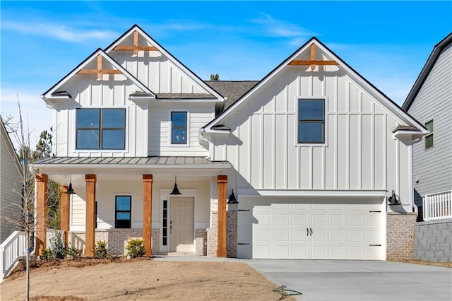 modern farmhouse style home featuring board and batten siding, covered porch, driveway, an attached garage, and a standing seam roof