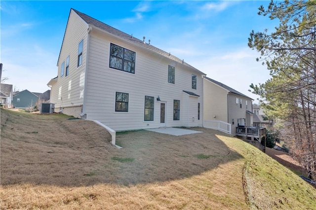 rear view of house featuring a patio, central air condition unit, and a yard