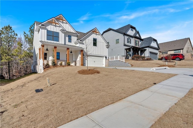 modern inspired farmhouse with board and batten siding, a residential view, covered porch, driveway, and an attached garage