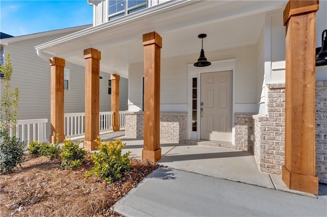 entrance to property featuring stone siding and a porch