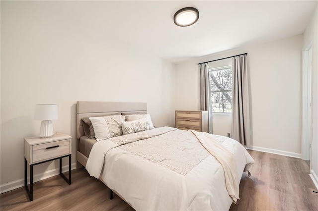 bedroom with baseboards and wood finished floors