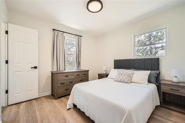 bedroom with baseboards and light wood finished floors