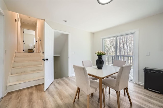 dining area with attic access and light wood-type flooring