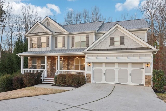 craftsman-style house featuring a garage, stone siding, a porch, and driveway