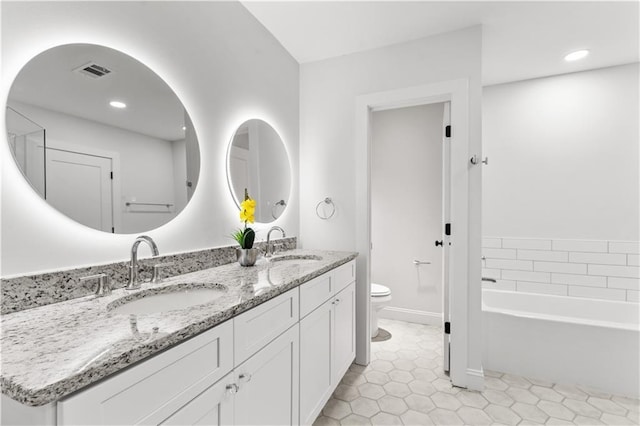 bathroom with vanity, a bath, tile patterned floors, and toilet