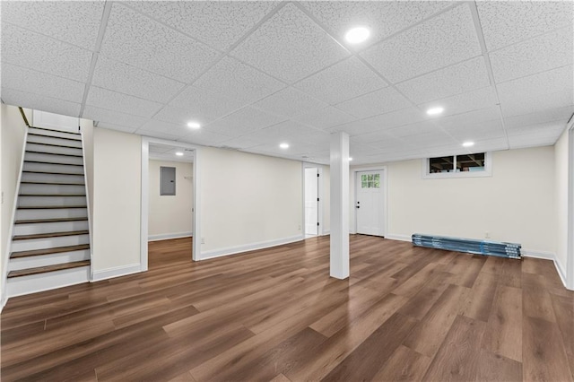 basement with dark wood-type flooring and electric panel