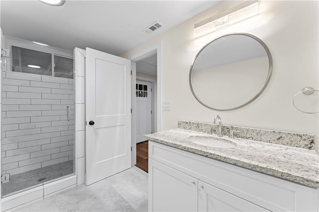 bathroom featuring vanity and a shower with shower door