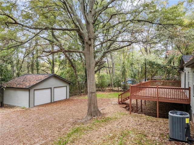 view of yard featuring an outbuilding, a wooden deck, a garage, and central AC unit