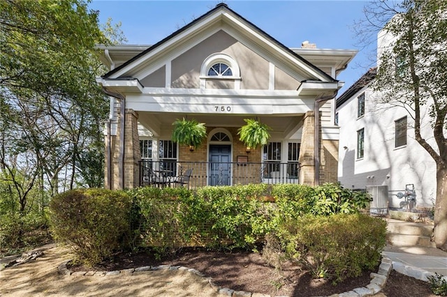 view of front of house featuring covered porch and brick siding