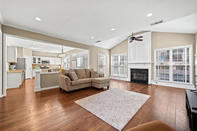 living room featuring ceiling fan, a fireplace, lofted ceiling, and dark hardwood / wood-style floors