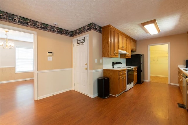 5425 Windswept Trce, Sugar Hill, GA 30518 - kitchen with white electric range oven, freestanding refrigerator, wood finished floors, light countertops, and a textured ceiling