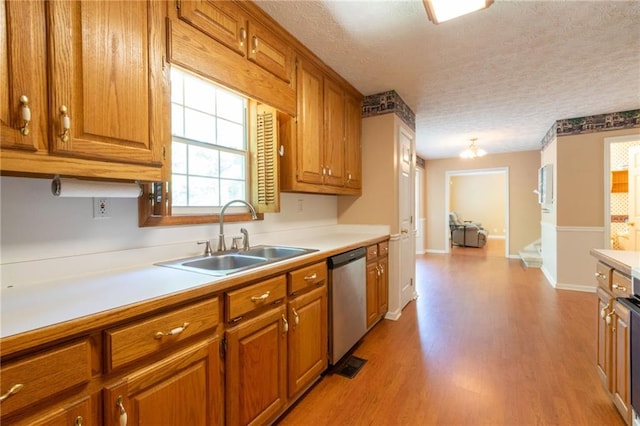 5425 Windswept Trce, Sugar Hill, GA 30518 - kitchen featuring stainless steel dishwasher, a sink, light countertops, a textured ceiling, and brown cabinets
