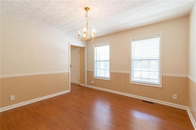 5425 Windswept Trce, Sugar Hill, GA 30518 - empty room with a chandelier, a textured ceiling, wood finished floors, and baseboards
