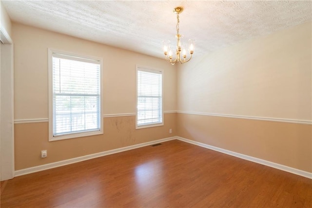 5425 Windswept Trce, Sugar Hill, GA 30518 - spare room featuring a chandelier, wood finished floors, a textured ceiling, and baseboards