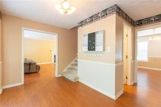 5425 Windswept Trce, Sugar Hill, GA 30518 - hallway featuring a chandelier, wood finished floors, stairs, baseboards, and a textured ceiling
