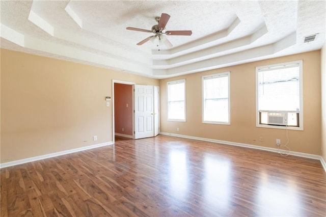 5425 Windswept Trce, Sugar Hill, GA 30518 - empty room with a tray ceiling, healthy amount of natural light, wood finished floors, and a textured ceiling