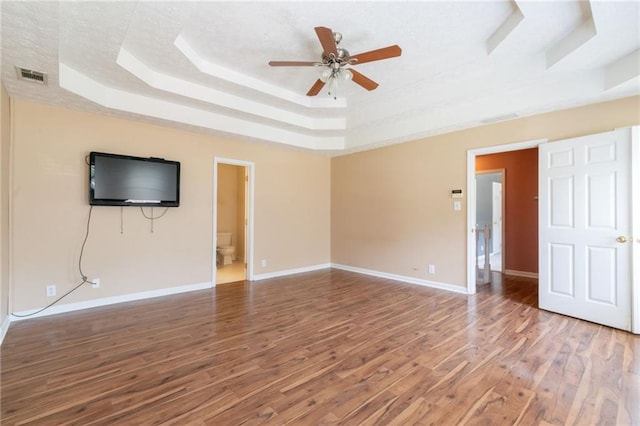 5425 Windswept Trce, Sugar Hill, GA 30518 - unfurnished living room featuring a tray ceiling, wood finished floors, ceiling fan, and baseboards