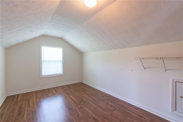 5425 Windswept Trce, Sugar Hill, GA 30518 - bonus room with dark wood-style floors, lofted ceiling, a textured ceiling, and baseboards