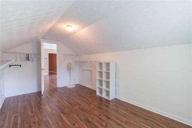 5425 Windswept Trce, Sugar Hill, GA 30518 - additional living space with a textured ceiling, wood finished floors, vaulted ceiling, and baseboards