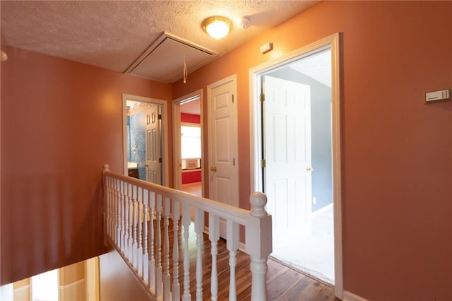 5425 Windswept Trce, Sugar Hill, GA 30518 - hallway featuring attic access, an upstairs landing, wood finished floors, baseboards, and a textured ceiling