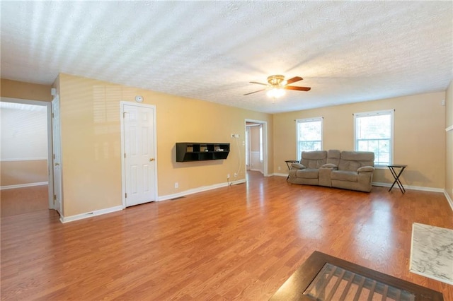 5425 Windswept Trce, Sugar Hill, GA 30518 - living area with a textured ceiling, ceiling fan, light wood-style floors, and baseboards