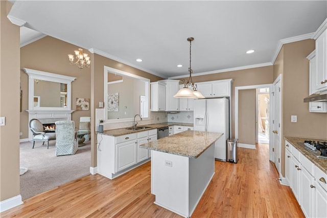 kitchen with a sink, decorative light fixtures, a center island, appliances with stainless steel finishes, and white cabinets