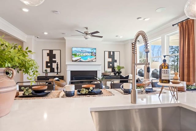 kitchen with ceiling fan, sink, and crown molding