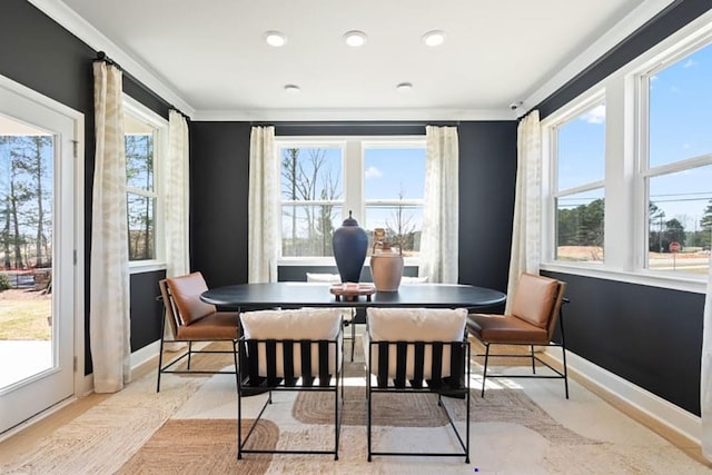 dining space with crown molding and light hardwood / wood-style flooring