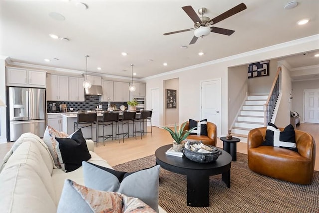 living room featuring ceiling fan, light hardwood / wood-style floors, and ornamental molding