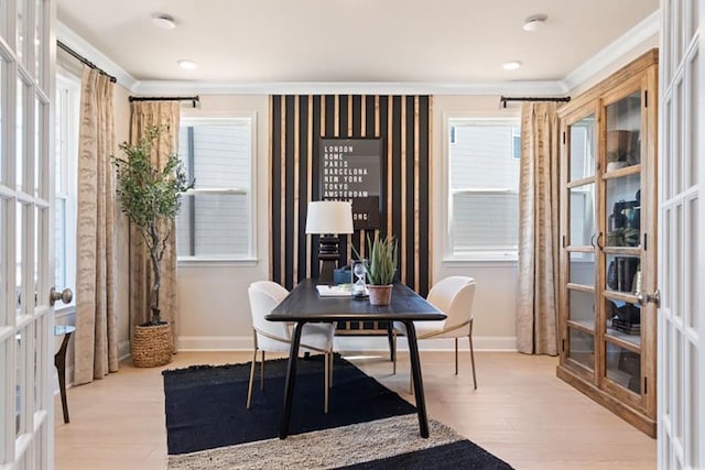 office space with light hardwood / wood-style floors, ornamental molding, french doors, and a healthy amount of sunlight