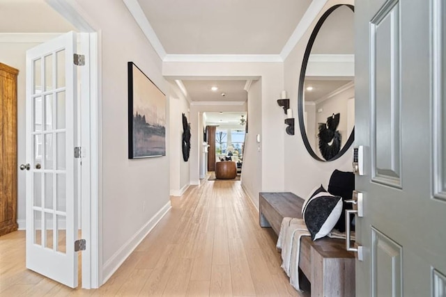 corridor featuring ornamental molding and light hardwood / wood-style flooring