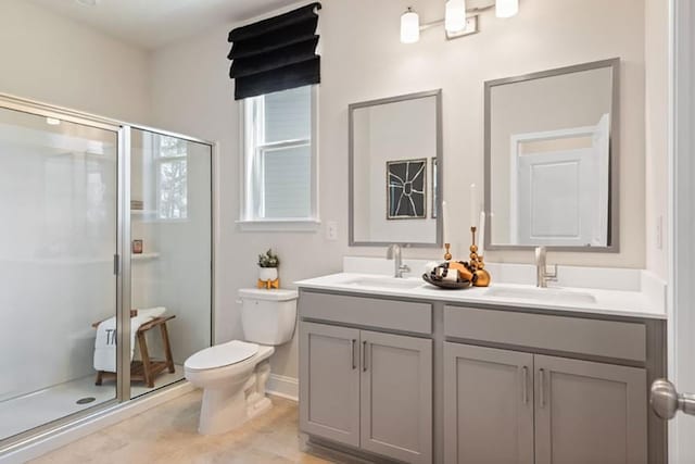 bathroom featuring an enclosed shower, vanity, and toilet