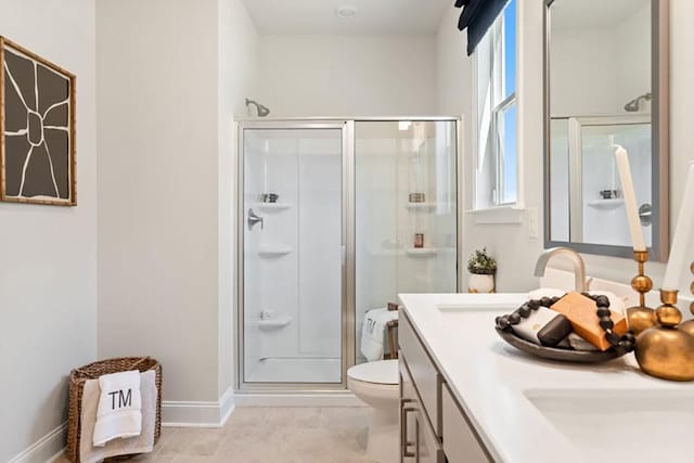 bathroom with an enclosed shower, vanity, a wealth of natural light, and toilet