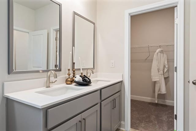 1446 Auburn Glen Rd, Dacula, GA 30019 - bathroom featuring double vanity, a spacious closet, and baseboards