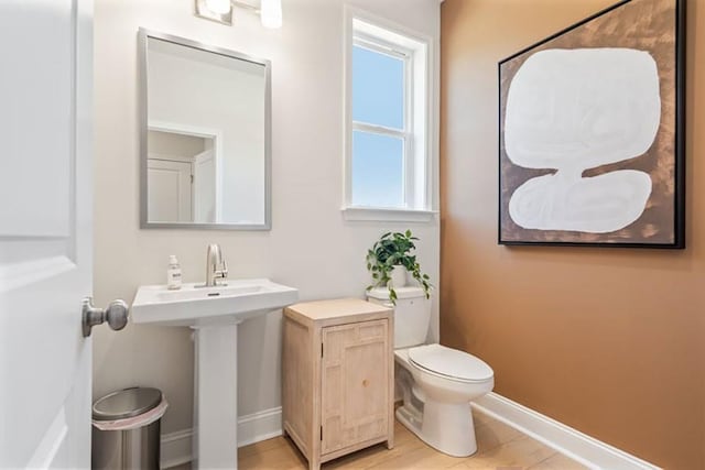 bathroom featuring sink, wood-type flooring, and toilet