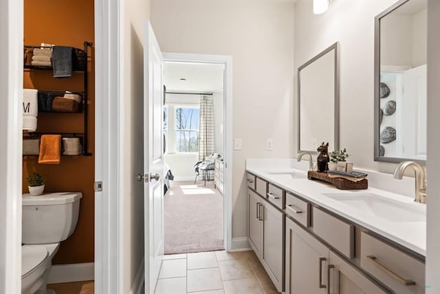 bathroom with toilet, vanity, and tile patterned flooring