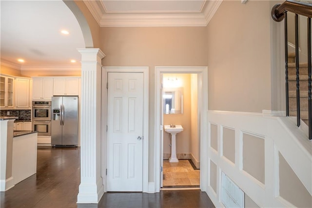 1137 Fortress Ave SW, Atlanta, GA 30315 - hallway featuring arched walkways, ornamental molding, dark wood-type flooring, and decorative columns