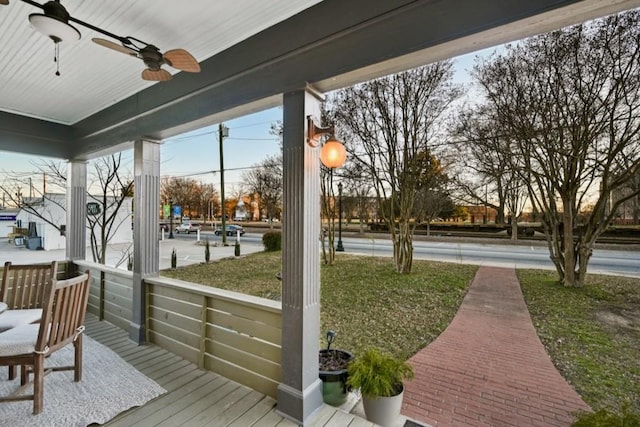 wooden deck featuring a yard and ceiling fan