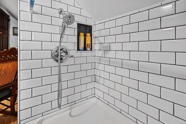 bathroom with vaulted ceiling and a tile shower