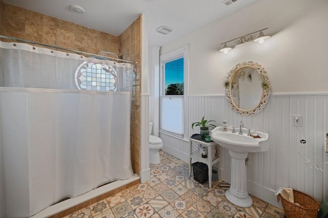 bathroom featuring walk in shower and toilet