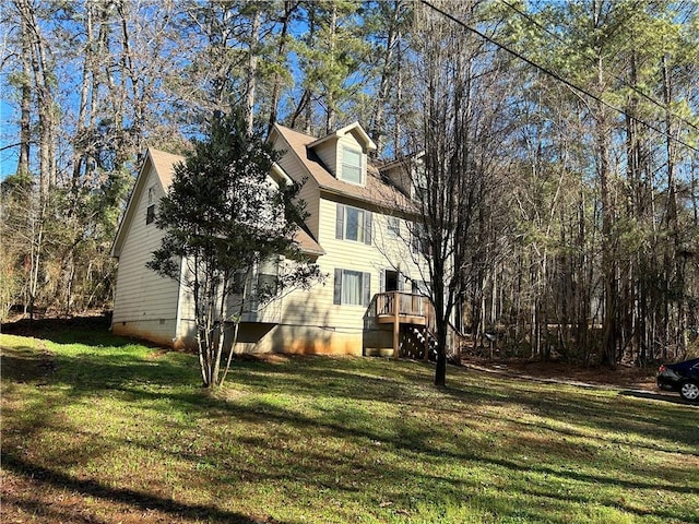 view of side of home with a wooden deck and a lawn