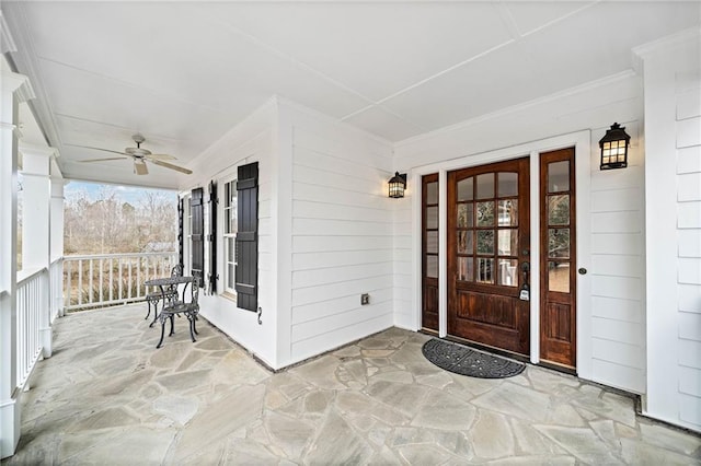 view of exterior entry with a ceiling fan and covered porch